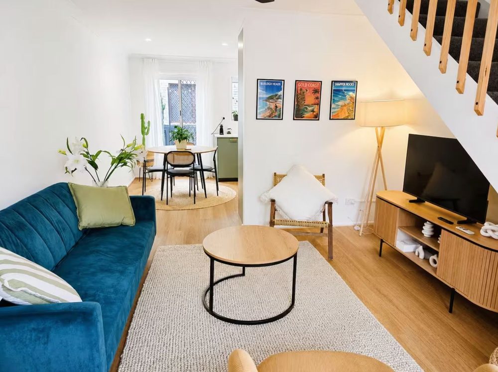 Light-filled living room with velvet sofa and Burleigh prints